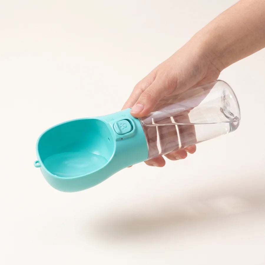 Eine Hand hält die Flasche waagrecht, der offene Napf zeigt zur Seite
